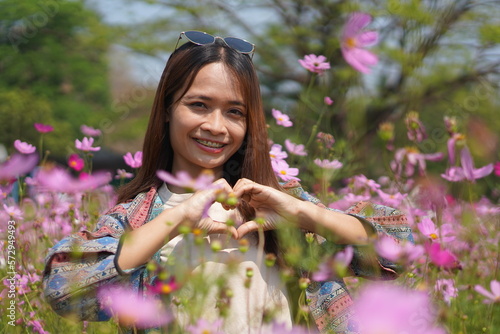 Happy Asian woman in cosmos flower garden