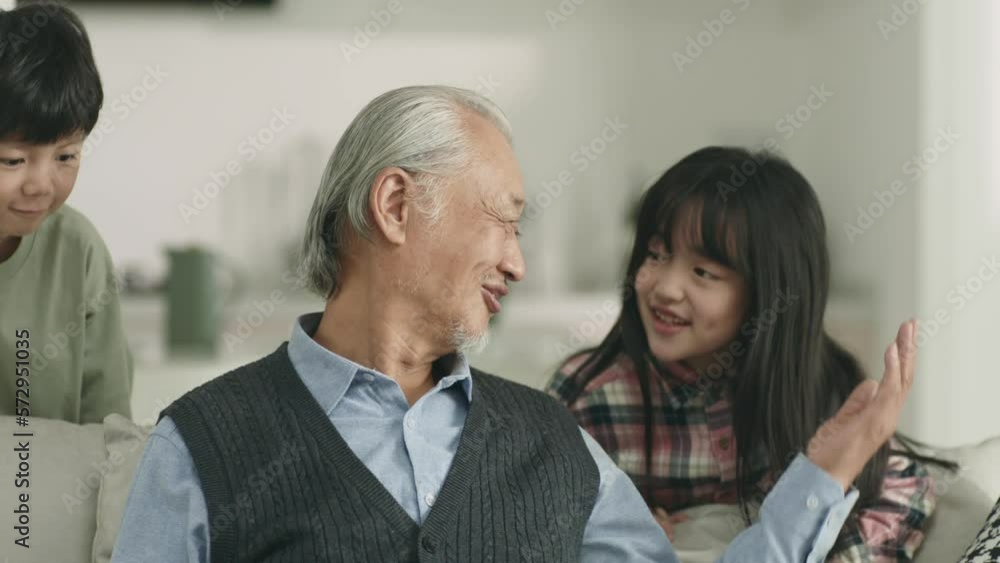 loving asian grandpa and two grandchildren relaxing at home loving asian grandpa and two grandchildren relaxing at home