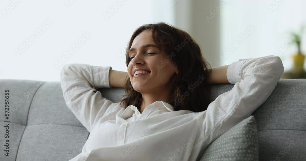 Peaceful happy pretty young woman relaxing on sofa at home, leaning on soft back, taking nap, break, smiling with closed eyes, sleeping, awaking, enjoying leisure Peaceful happy pretty young woman relaxing on sofa at home, leaning on soft back, taking nap, break, smiling with closed eyes, sleeping, awaking, enjoying leisure