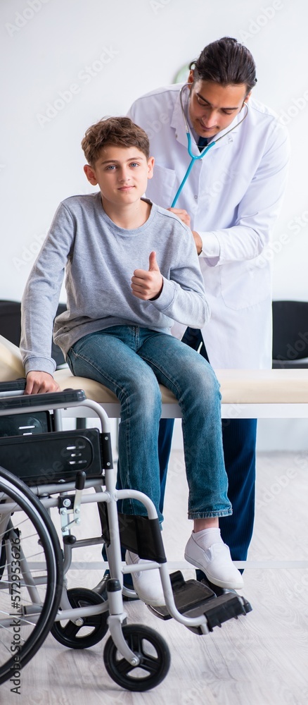 Young male doctor pediatrist and boy in wheel-chair Young male doctor pediatrist and boy in wheel-chair