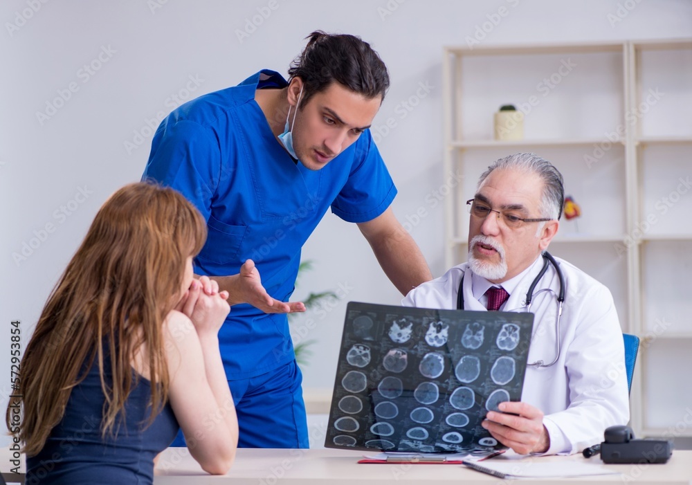 Obraz premium Two doctors examining young woman