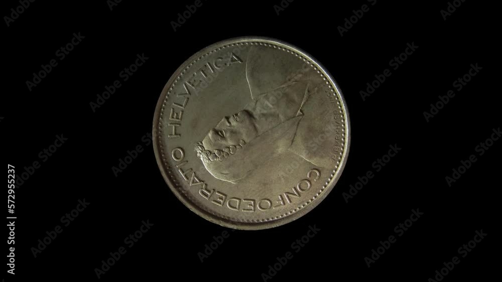 Obverse of Switzerland coin 5 francs with portrait of an alpine herdsman and inscription meaning SWISS FEDERATION, isolated in black background. 4k video Obverse of Switzerland coin 5 francs with portrait of an alpine herdsman and inscription meaning SWISS FEDERATION, isolated in black background. 4k video
