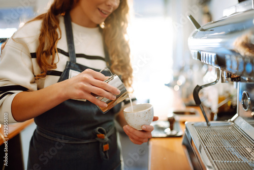 Leinwand Poster Female barista making coffee in a coffee machine