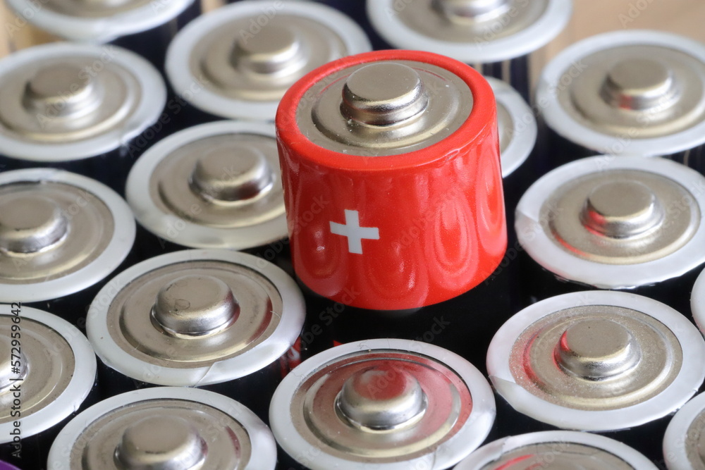 many round batteries and one red battery - obrazy, fototapety, plakaty 