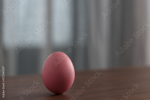 Pink Easter egg on a wooden table with copy space
