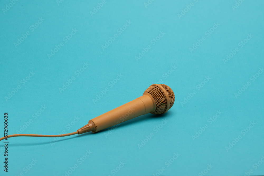 Golden karaoke microphone on a blue background Golden karaoke microphone on a blue background