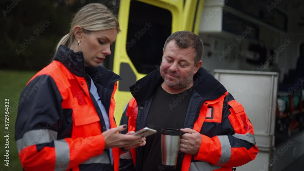 Rescuers having break in front of ambulance car, talking and drinking coffee. Rescuers having break in front of ambulance car, talking and drinking coffee.