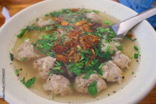 Delicious Khao Piak Pa or Lao Noodle soup with Fish meatballs in white bowl