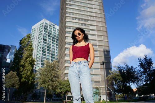 Portrait in the city of a serious asian woman standing looking at camera. High quality photo