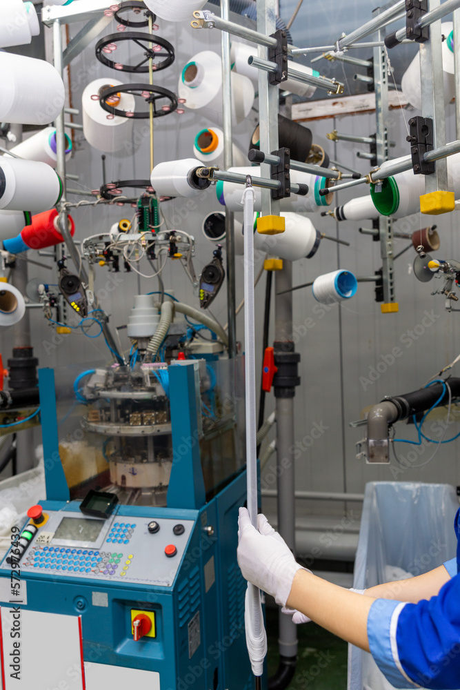 A female employee performs visual quality control of hosiery. A female employee performs visual quality control of hosiery.