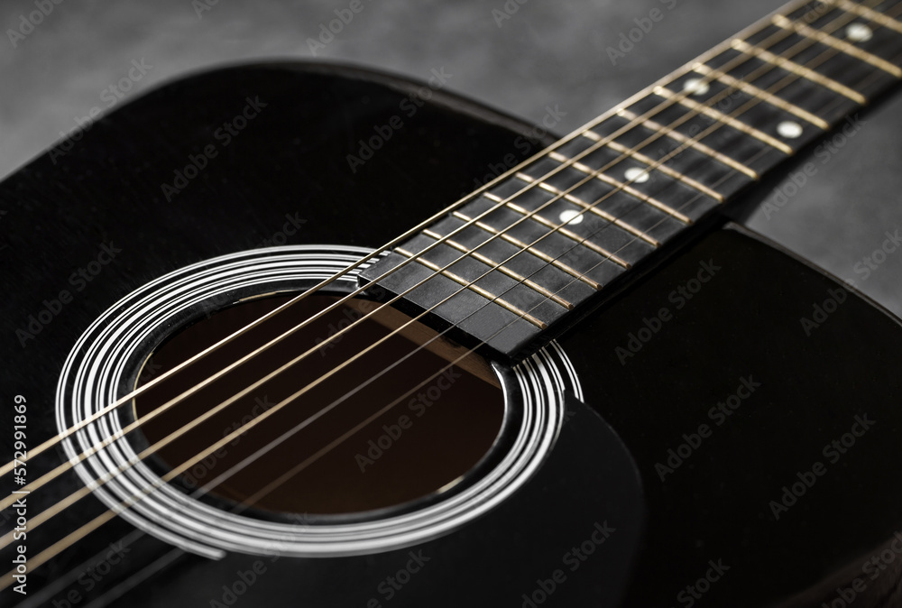 Guitar black, polished smooth soundboard, stretched strings, copper frets on neck, close-up selective focus Guitar black, polished smooth soundboard, stretched strings, copper frets on neck, close-up selective focus