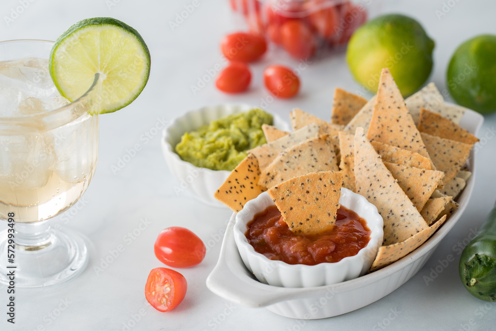 Crispy homemade keto diet tortilla chips served with cold beverage and dips.