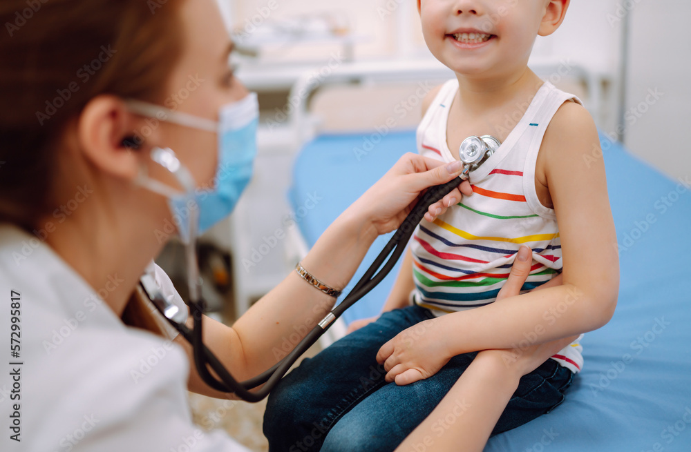 Female Doctor examining a little boy by stethoscope. Сhild's health