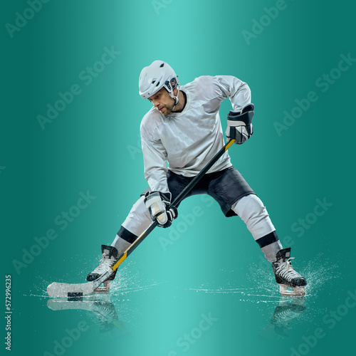Canvas Print Professional ice hockey player hitting puck for winning goal in action on gradient multicolored neon background
