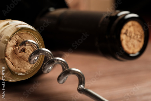 Two bottles of wine, corkscrew in a wine bottle photo