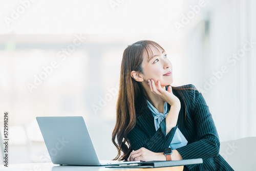 パソコンの前に座る日本人ビジネスウーマン