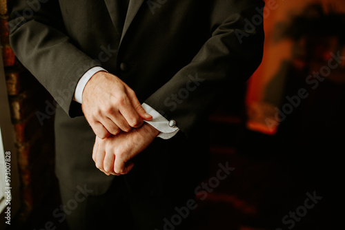Man adjusts cufflink