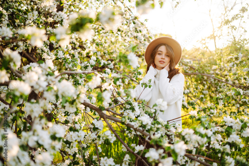 Young beautiful woman relaxing in blooming garden. Spring, romantic and lifestyle concept. Young beautiful woman relaxing in blooming garden. Spring, romantic and lifestyle concept.