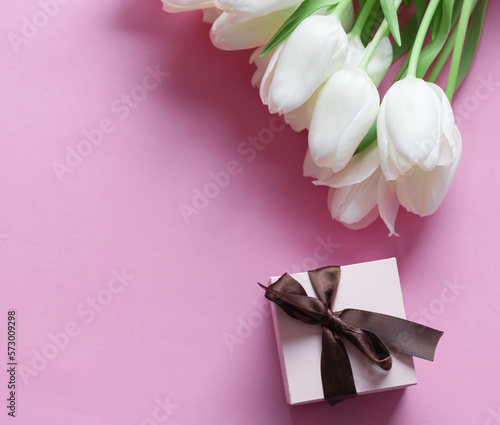Fototapeta Naklejka Na Ścianę i Meble -  White tulips on a pink background and a gift. holiday.