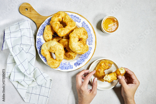 woman hand eating a traditional Algerian fried baked  donuts or pancake named Sfenj  photo