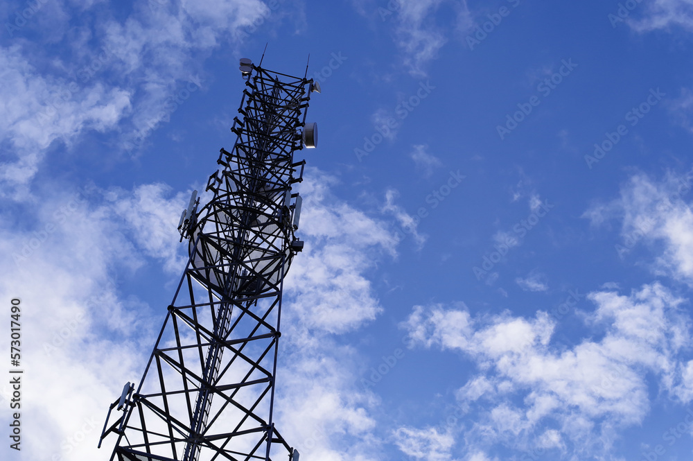 Wieża telefonii komórkowej na tle błękitnego nieba z chmurami. Wieża telefonii komórkowej na tle błękitnego nieba z chmurami.