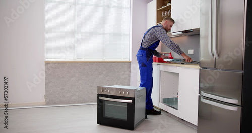 Papier peint Young Repairman Installing Induction Cooker