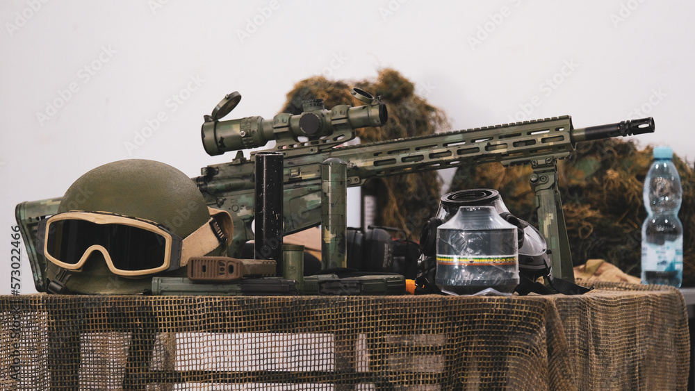 Helmet, ammunition, gas mask, military equipment on a camouflage net on the table
