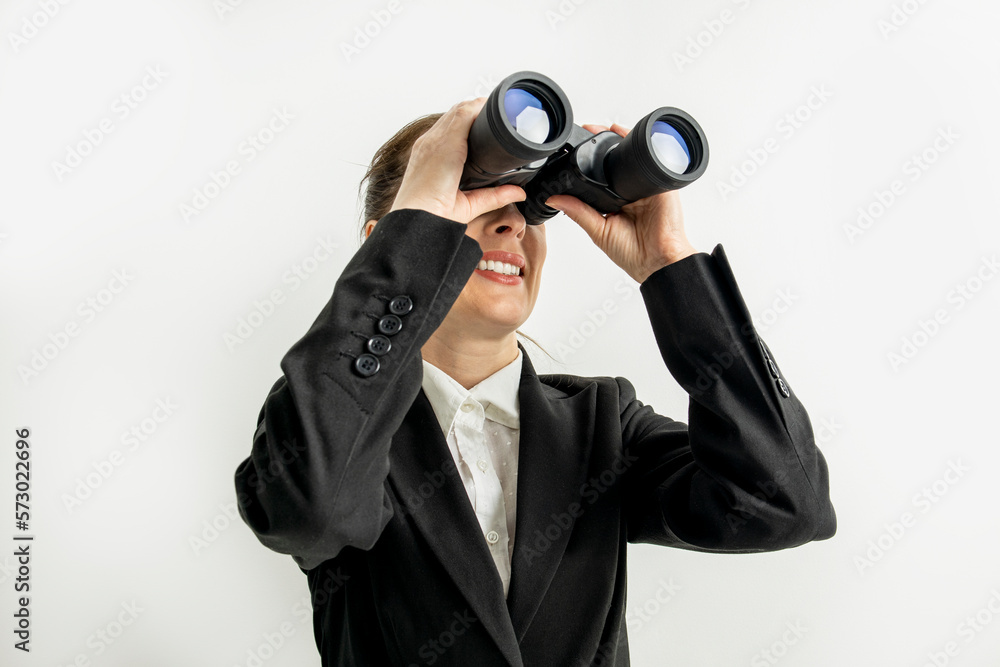 Smiling business woman in jacket looking through binoculars on white background Smiling business woman in jacket looking through binoculars on white background
