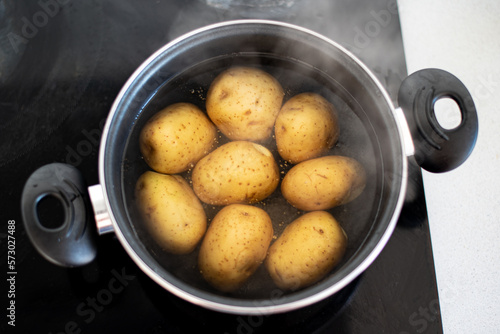 Varias patatas cociéndose en una olla con agua hirviendo. Concepto de preparar una receta con patatas cocidas. Agua en ebullición photo