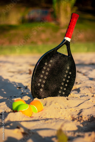 Beach tennis ball and racket on the court