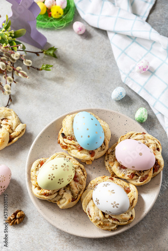 Easter composition. Sweet Italian Easter Bread Rings from puff pastry and dyed eggs on a stone background. Copy space.