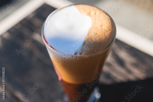 Cup of greek ice cold coffee on a table, frappe, glass of freddo, fredo capuchino served in street cafe taverna, Corfu island, Kerkyra, Greece, greek coffee concept in a summer sunny day photo