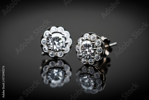Elegant shiny Sparky platinum and diamond earrings with black background. Generative AI