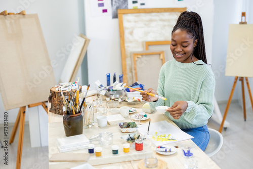 Young artist working in her painting studio