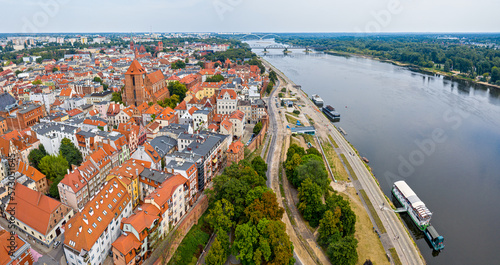 Toruń, promenada nad rzeką Wisła, widok w kierunku wschodnim na średniowieczną część miasta i most kolejowy 