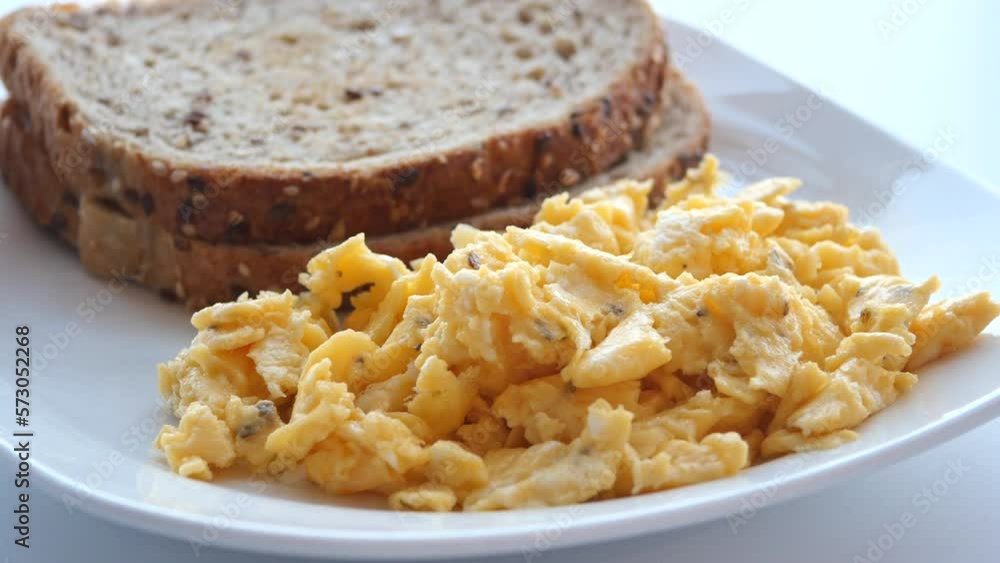 morning breakfast with Scrambled eggs on a bread on white plate morning breakfast with Scrambled eggs on a bread on white plate