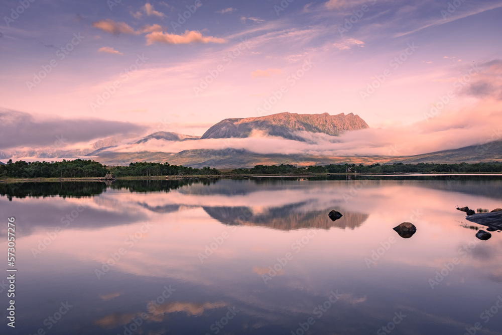 Fototapeta premium Spectacular reflection of the mountains on a lake with mist under the midnight sun, fairy tale atmosphere in the Vesteralen Islands, Norway
