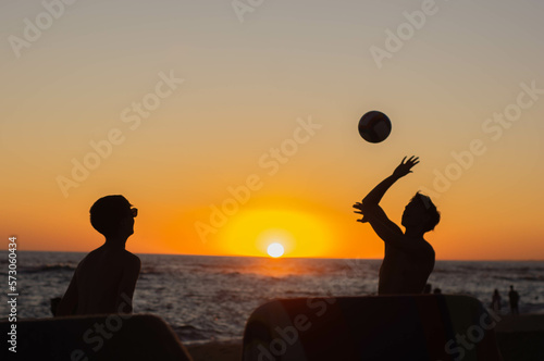 silhouette of a person with a ball at sunset