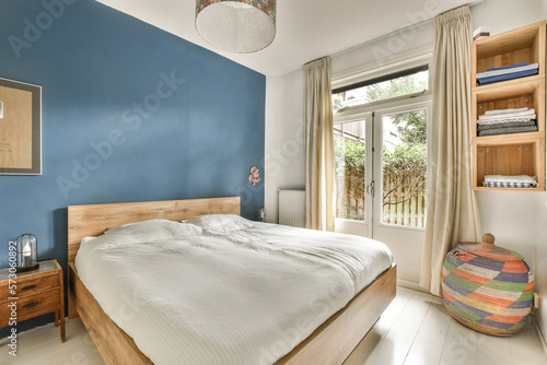 a bedroom with blue walls and white flooring, wooden headboards and a bed in front of a window photo