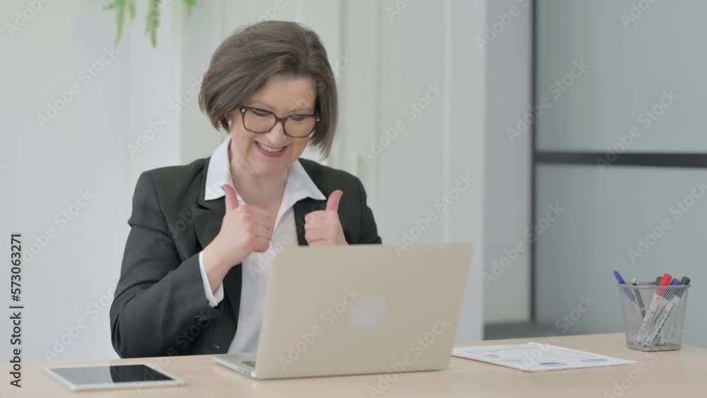 Old Businesswoman Celebrating Online Success on Laptop in Office Old Businesswoman Celebrating Online Success on Laptop in Office