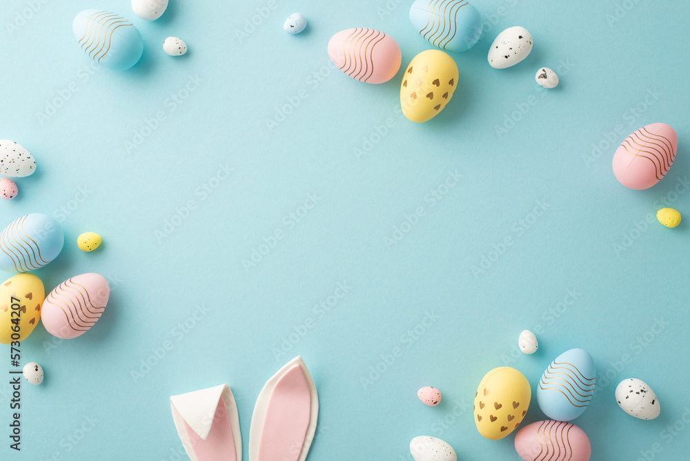 Easter party concept. Top view photo of easter bunny ears white pink blue and yellow eggs on isolated pastel blue background with copyspace in the middle - obrazy, fototapety, plakaty 