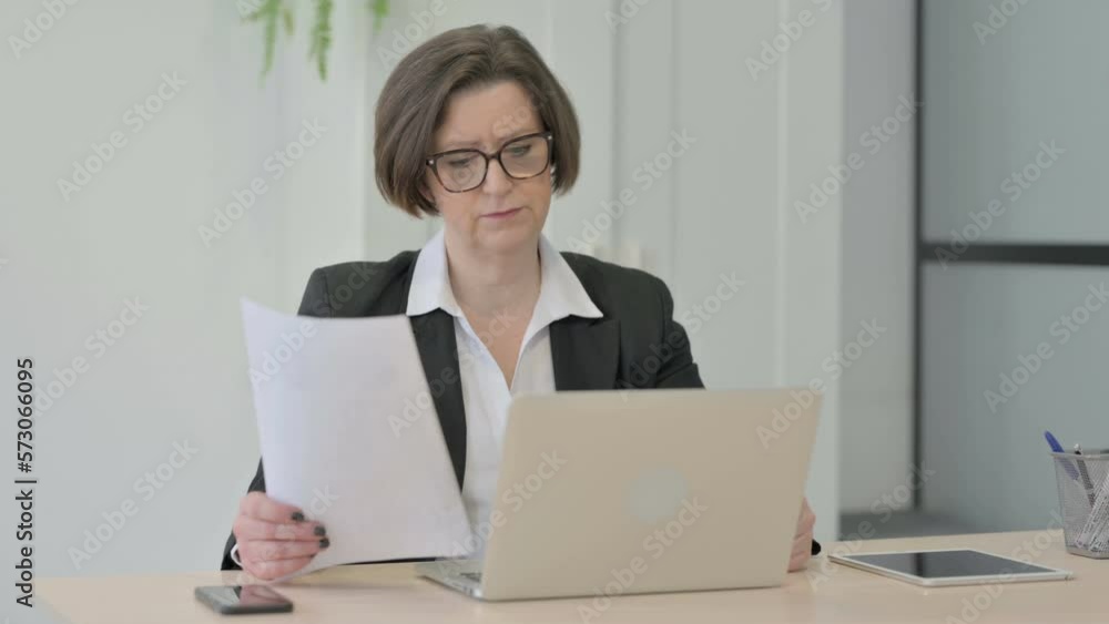 Old Businesswoman Feeling Upset while Doing Paperwork Old Businesswoman Feeling Upset while Doing Paperwork