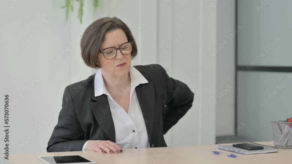 Old Businesswoman having Back Pain in Office Old Businesswoman having Back Pain in Office