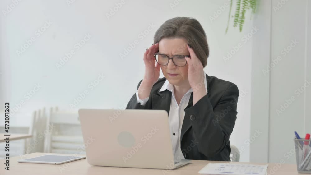 Old Businesswoman having Headache while Working on Laptop Old Businesswoman having Headache while Working on Laptop