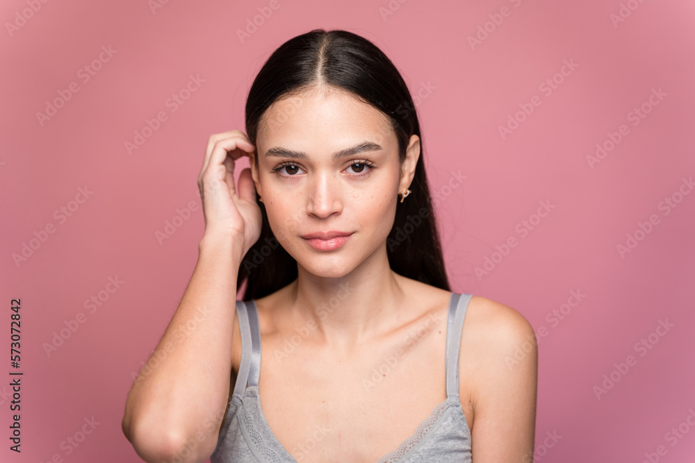 Young woman with makeup against pink background Young woman with makeup against pink background