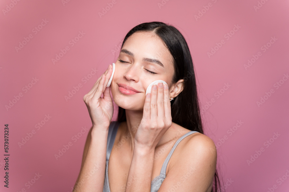 Young woman wiping makeup with absorbent cotton Young woman wiping makeup with absorbent cotton