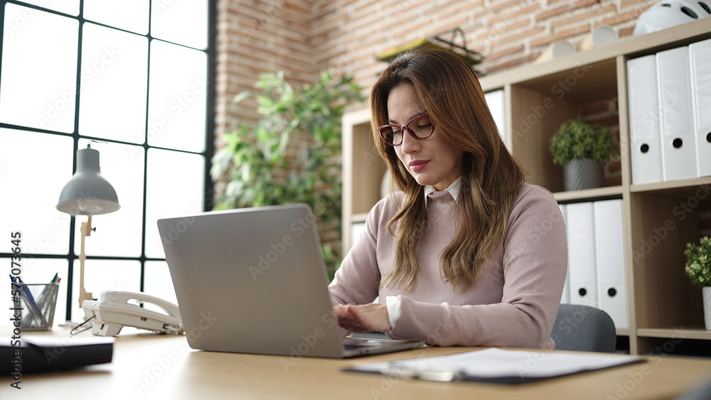 Young beautiful hispanic woman business worker using laptop working at office Young beautiful hispanic woman business worker using laptop working at office