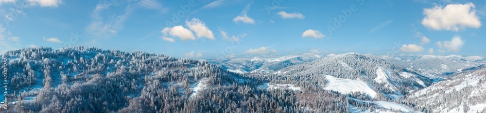 Winter Carpathian Mountains landscape with fir forest and lonely house on slopes (Skole, Lviv Oblast, Ukraine).