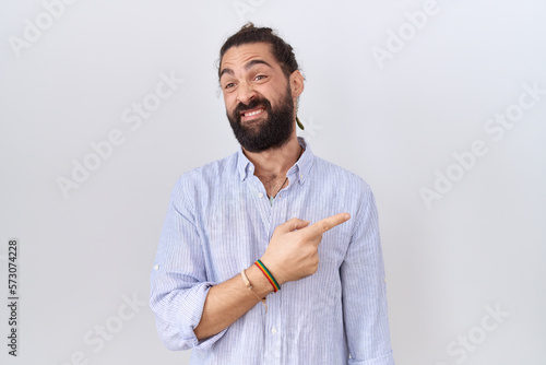 Hispanic man with beard wearing casual shirt pointing aside worried and nervous with forefinger, concerned and surprised expression © Krakenimages.com