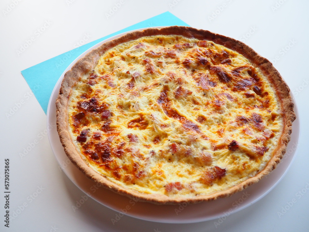 Homemade traditional french Quiche Lorraine, real recipe, white and blue background
